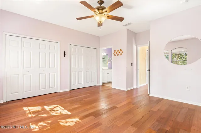 a view of a livingroom with a ceiling fan and wooden floor