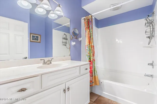 a bathroom with a sink mirror vanity and bathtub