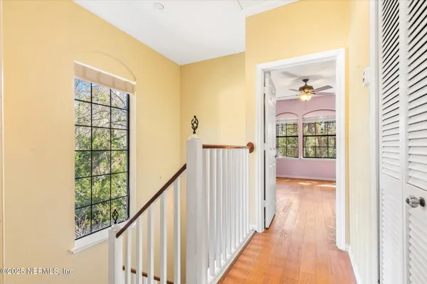 a view of a hallway with wooden floor and windows