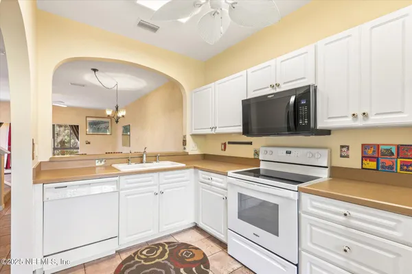 a kitchen with appliances a sink and cabinets