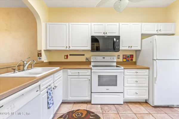 a kitchen with cabinets stainless steel appliances and sink