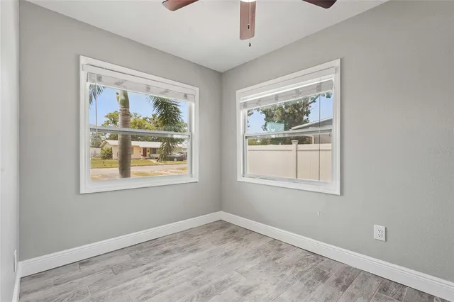 an empty room with a window and wooden floor