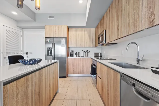 a kitchen with stainless steel appliances granite countertop a sink stove and refrigerator