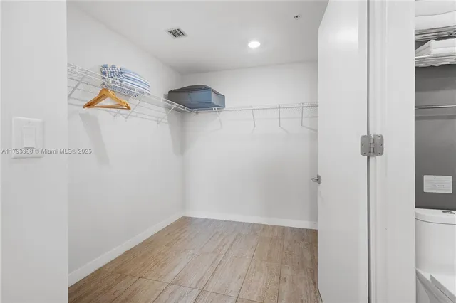 a view of a room with wooden floor and white walls