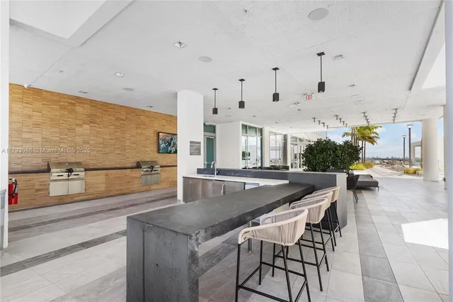 a kitchen with stainless steel appliances kitchen island granite countertop a table and chairs in it