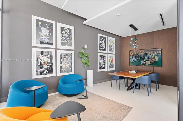 a living room with furniture a rug and wall paintings