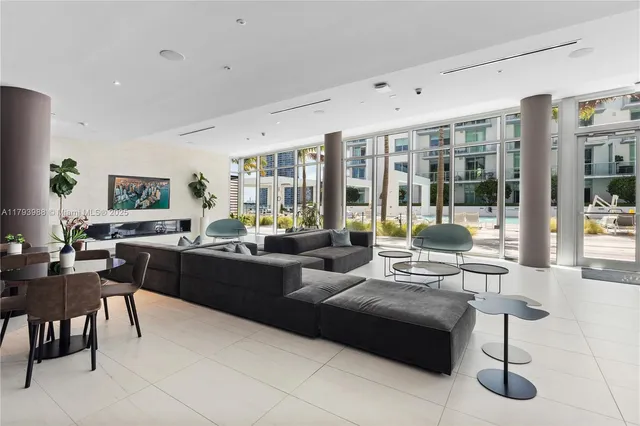 a living room with furniture large windows and wooden floor