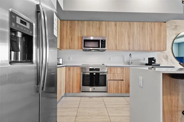 a kitchen with stainless steel appliances granite countertop a refrigerator and a stove top oven