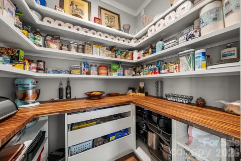 a utility room with stainless steel appliances cabinets and a book shelf