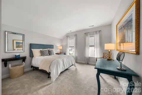 a bedroom with a bed and a dresser next to a window