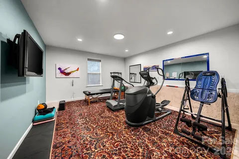 a room with gym equipment and a flat screen tv