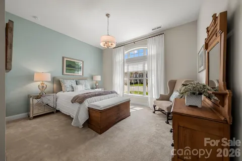 a spacious bedroom with a bed and a chandelier