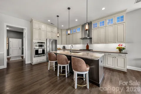 a kitchen with granite countertop wooden floors cabinets a dining table and chairs