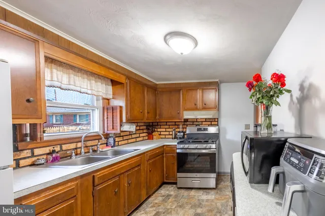 a kitchen with granite countertop a sink stainless steel appliances and cabinets