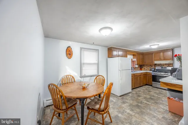 a view of a dining room with furniture and a kitchen