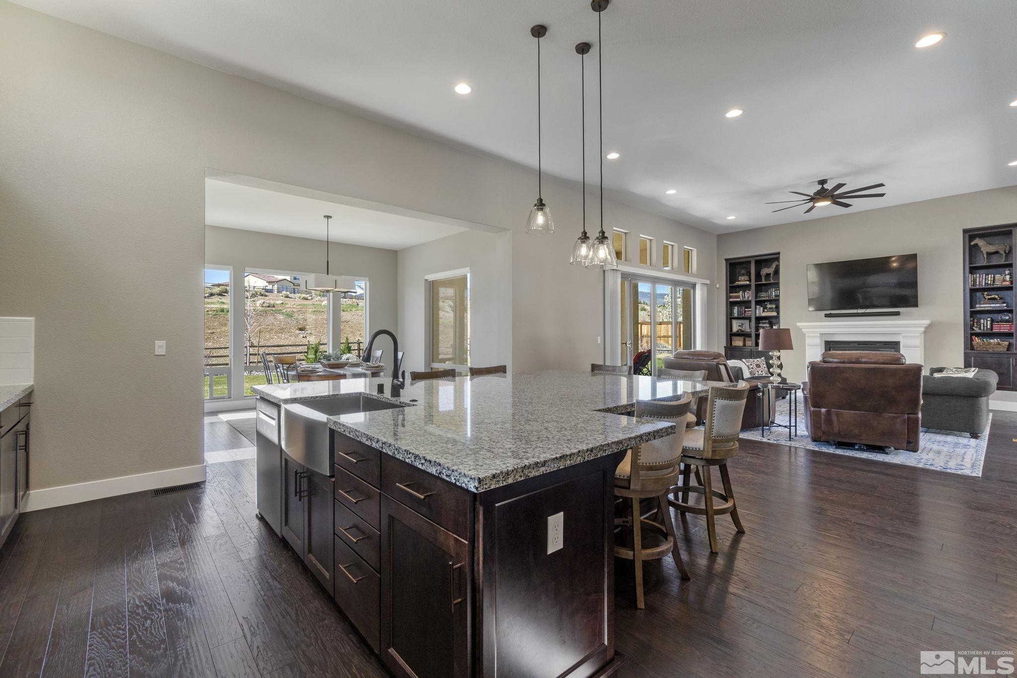 13357 Travertine Lane Reno, NV 89511 - Photo 16 of 39 a kitchen with stainless steel appliances granite countertop a kitchen island a stove a table and chairs