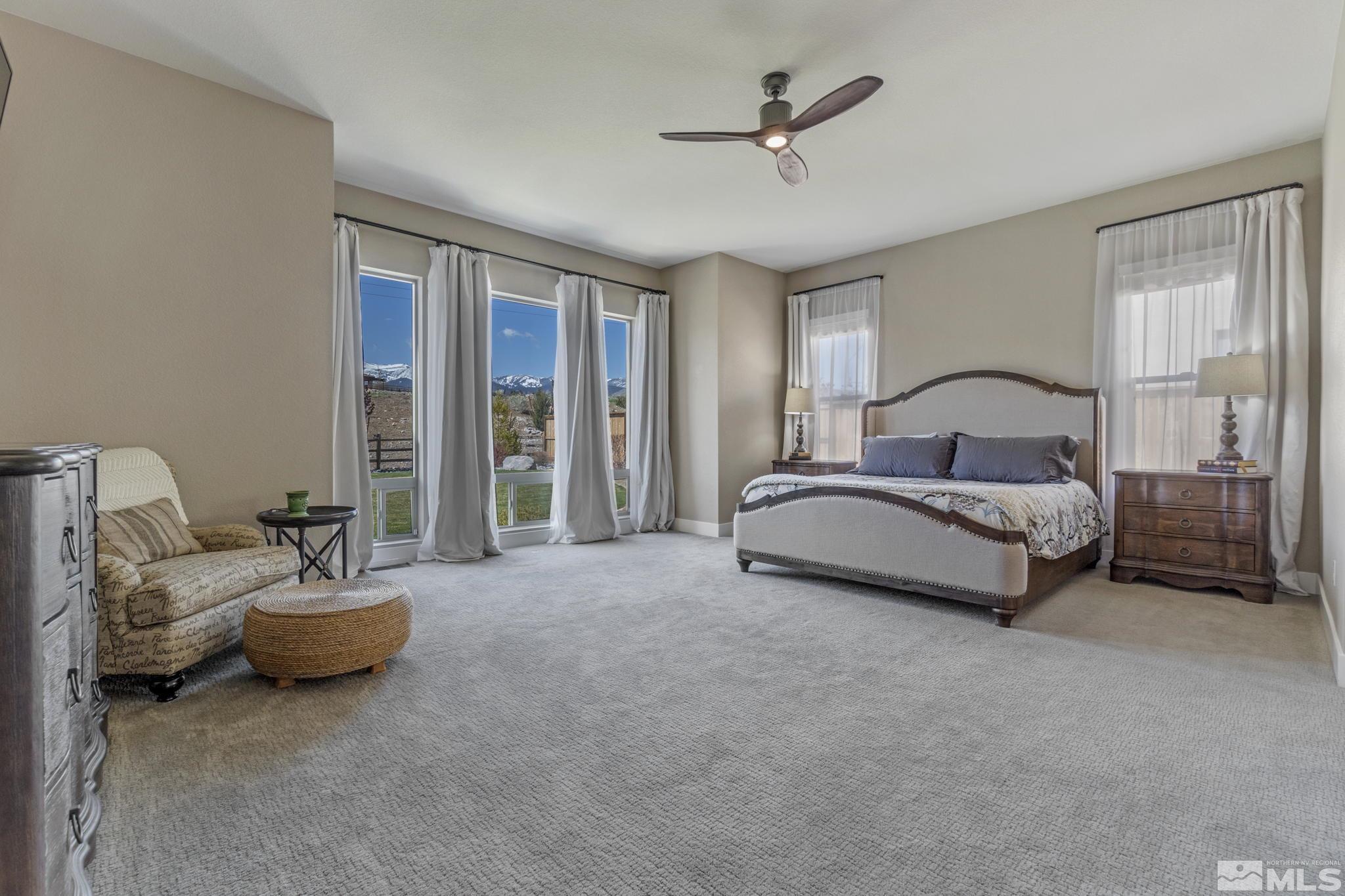 13357 Travertine Lane Reno, NV 89511 - Photo 23 of 39 a spacious bedroom with a bed and a chandelier