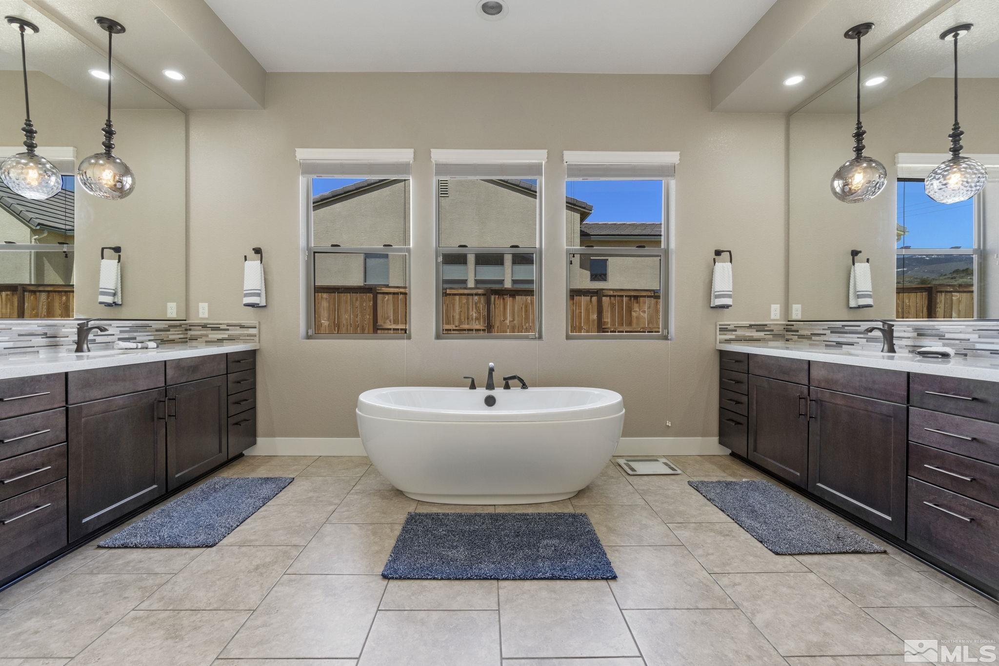 13357 Travertine Lane Reno, NV 89511 - Photo 27 of 39 a bathroom with a sink a large mirror and a bathtub