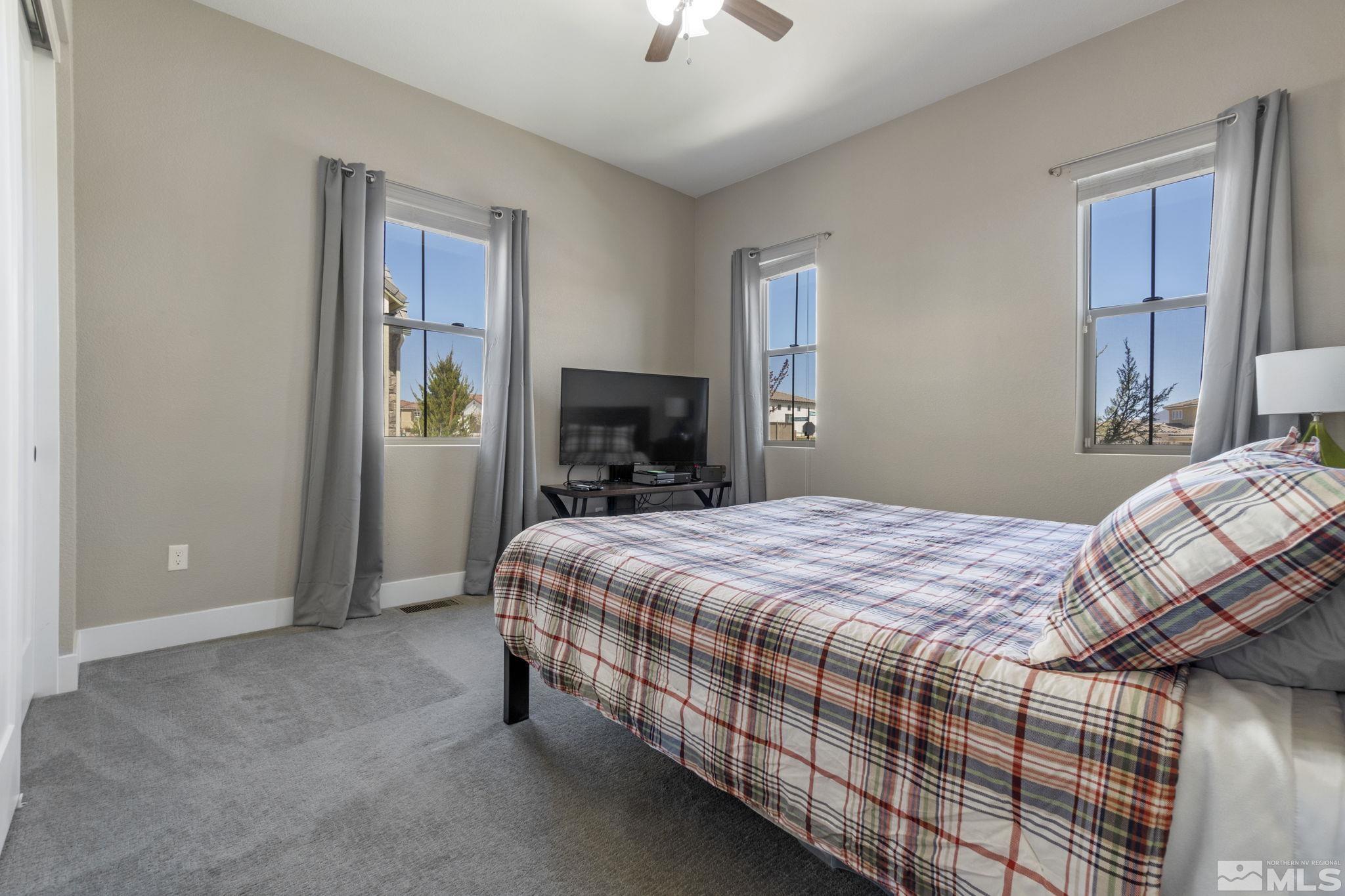 13357 Travertine Lane Reno, NV 89511 - Photo 31 of 39 a bedroom with a bed and a chandelier