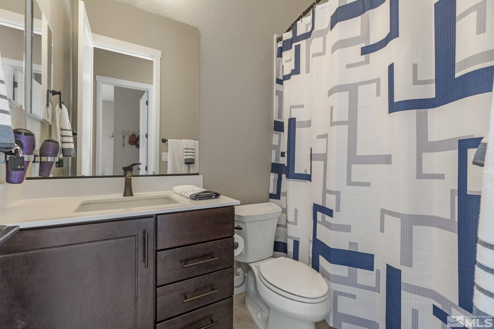 13357 Travertine Lane Reno, NV 89511 - Photo 33 of 39 a bathroom with a granite countertop toilet sink and a mirror