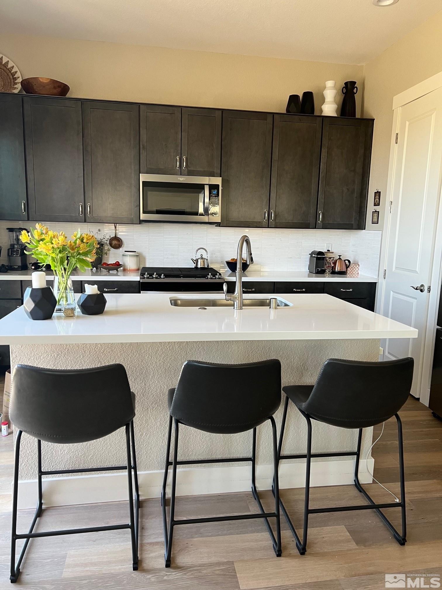 2833 Thistle Pine Court Reno, NV 89521 - Photo 6 of 25 a kitchen with stainless steel appliances kitchen island granite countertop a table chairs and a refrigerator