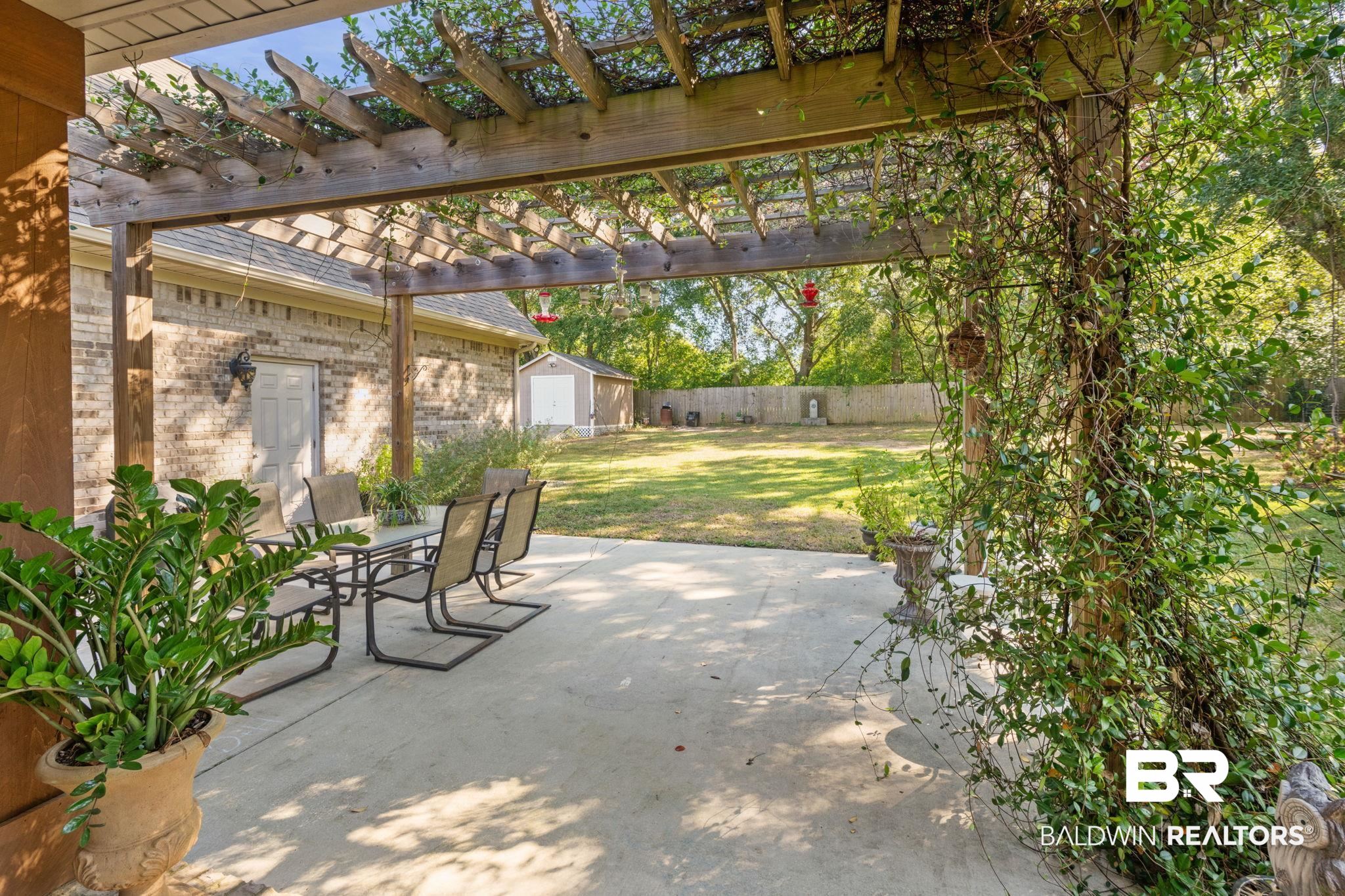 4331 Hamilton Oaks Lane Mobile, AL 36695 - Photo 26 of 38 View of patio / terrace with a storage unit, a pergola, an outdoor structure, and outdoor dining area