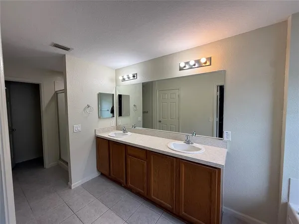 a bathroom with a double vanity sink and a mirror