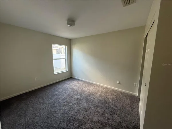 an empty room with windows and closet