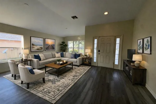 a living room with furniture and a wooden floor
