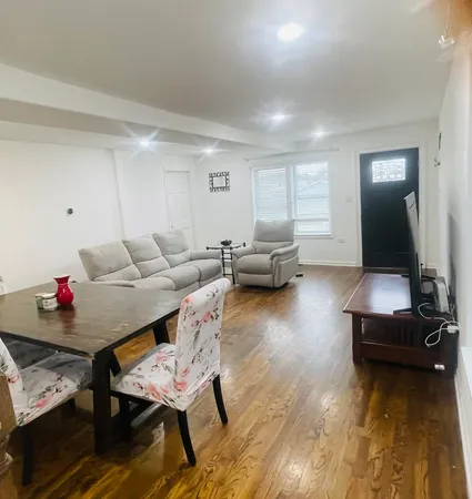 a living room with furniture and a wooden floor