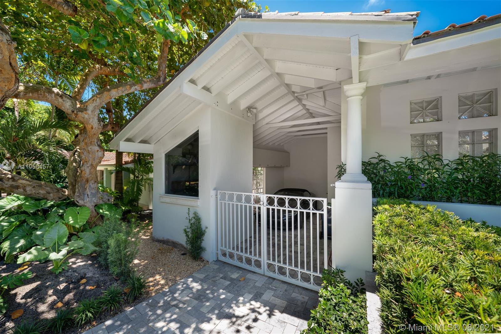 320 Pacific Road Key Biscayne, FL 33149 - Photo 11 of 27 a view of a house with a small yard plants and large tree