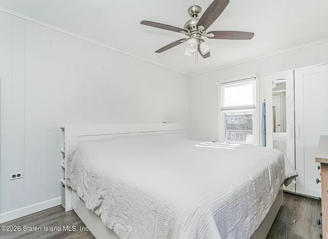 a bedroom with a bed and a ceiling fan