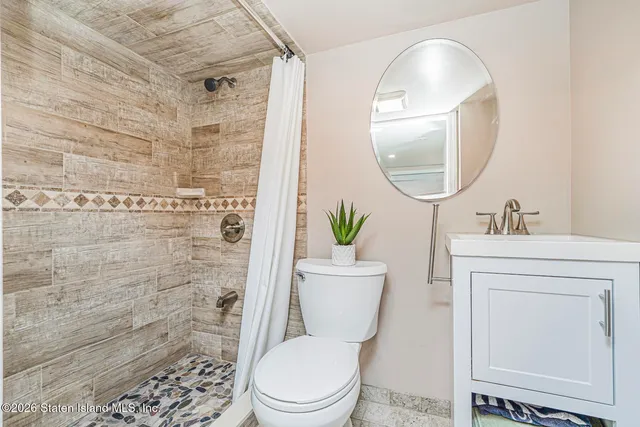 a bathroom with a toilet a sink and a mirror