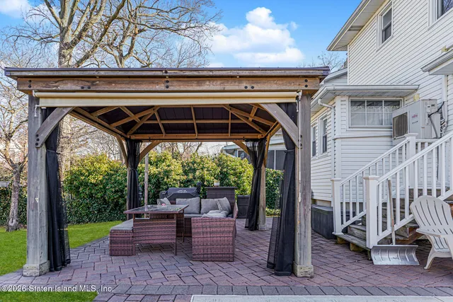 a view of a porch with furniture and a yard