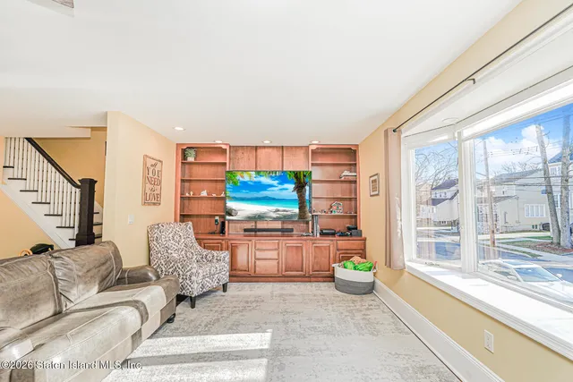 a living room with furniture a flat screen tv and a large window