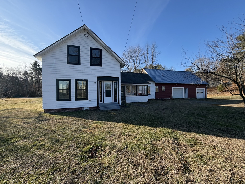 a view of a yard in front of a house with large windows