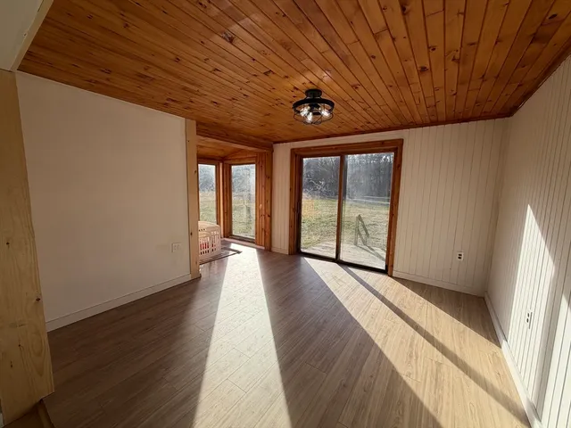 a view of a hall with wooden floor and windows