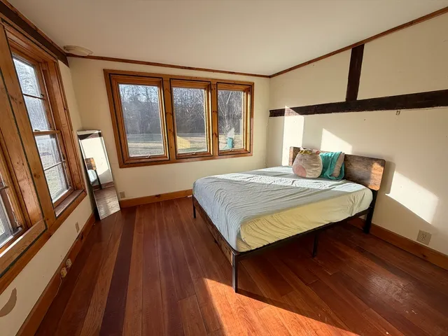a bedroom with a bed and wooden floor