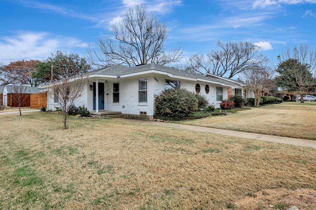 a front view of house with yard and trees around