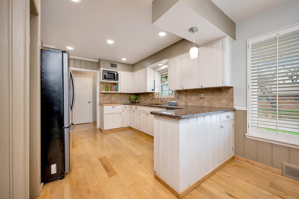 10005 Ridgehaven Drive Dallas, TX 75238 - Photo 10 of 27 a kitchen with kitchen island granite countertop a refrigerator a sink a stove a microwave and island