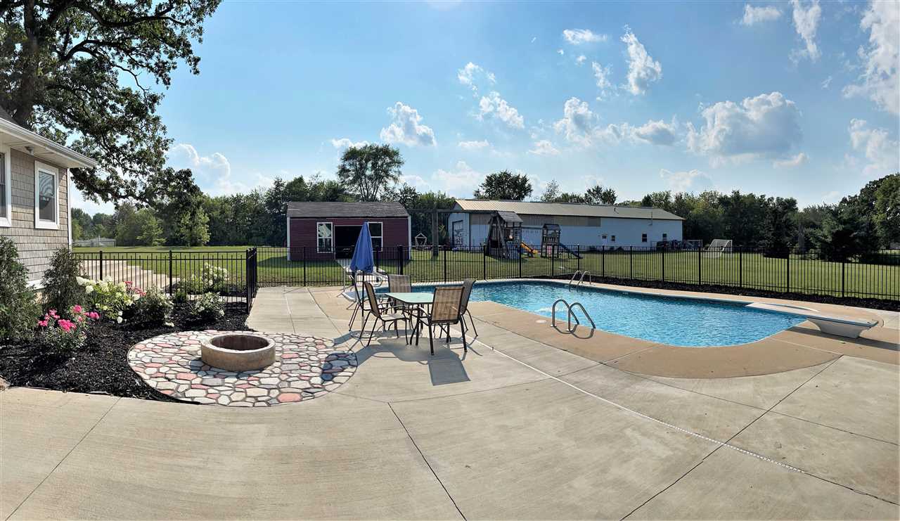 7545 Kishwaukee Road Stillman Valley, IL 61084 - Photo 45 of 61 a view of a swimming pool with sitting area and fire pit
