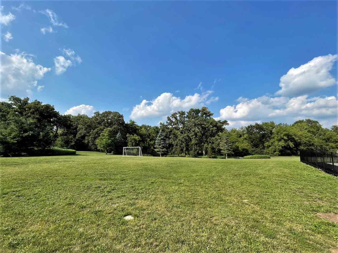 7545 Kishwaukee Road Stillman Valley, IL 61084 - Photo 5 of 61 a view of a grassy field with an trees