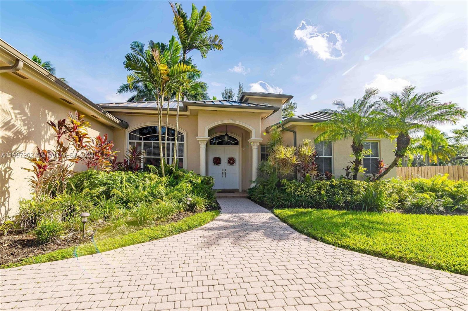 9750 Southwest 143rd Street Miami, FL 33176 - Photo 2 of 41 a front view of a house with a garden