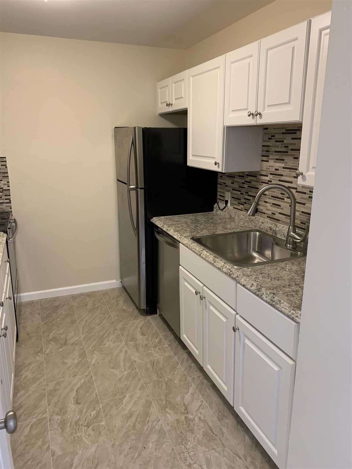 10 White Gate Road, Unit J Wappingers Falls, NY 12590 - Photo 4 of 11 a kitchen with granite countertop a refrigerator sink and cabinets