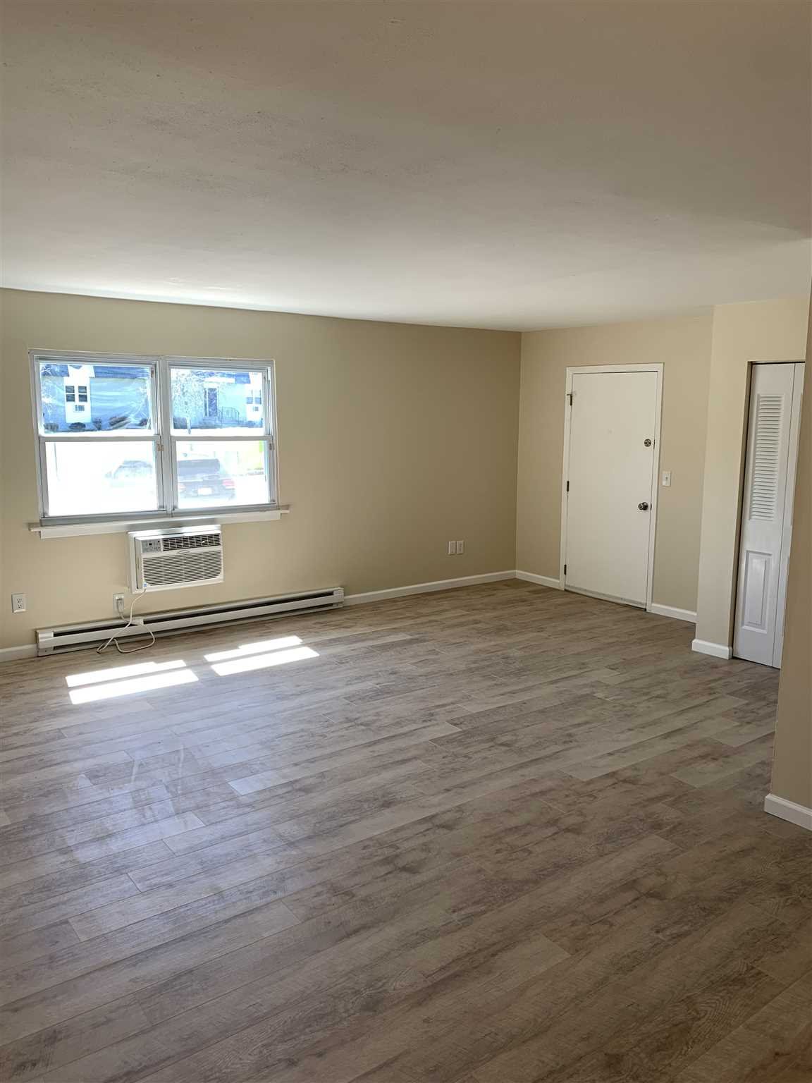 10 White Gate Road, Unit J Wappingers Falls, NY 12590 - Photo 5 of 11 an empty room with wooden floor and windows