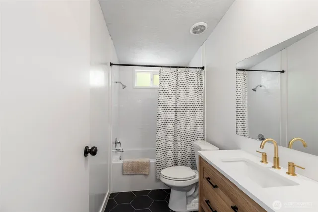 a bathroom with a sink toilet vanity and shower