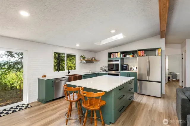 a kitchen with stainless steel appliances granite countertop a refrigerator and a stove top oven