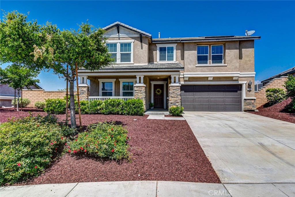 a front view of a house with a yard and potted plants
