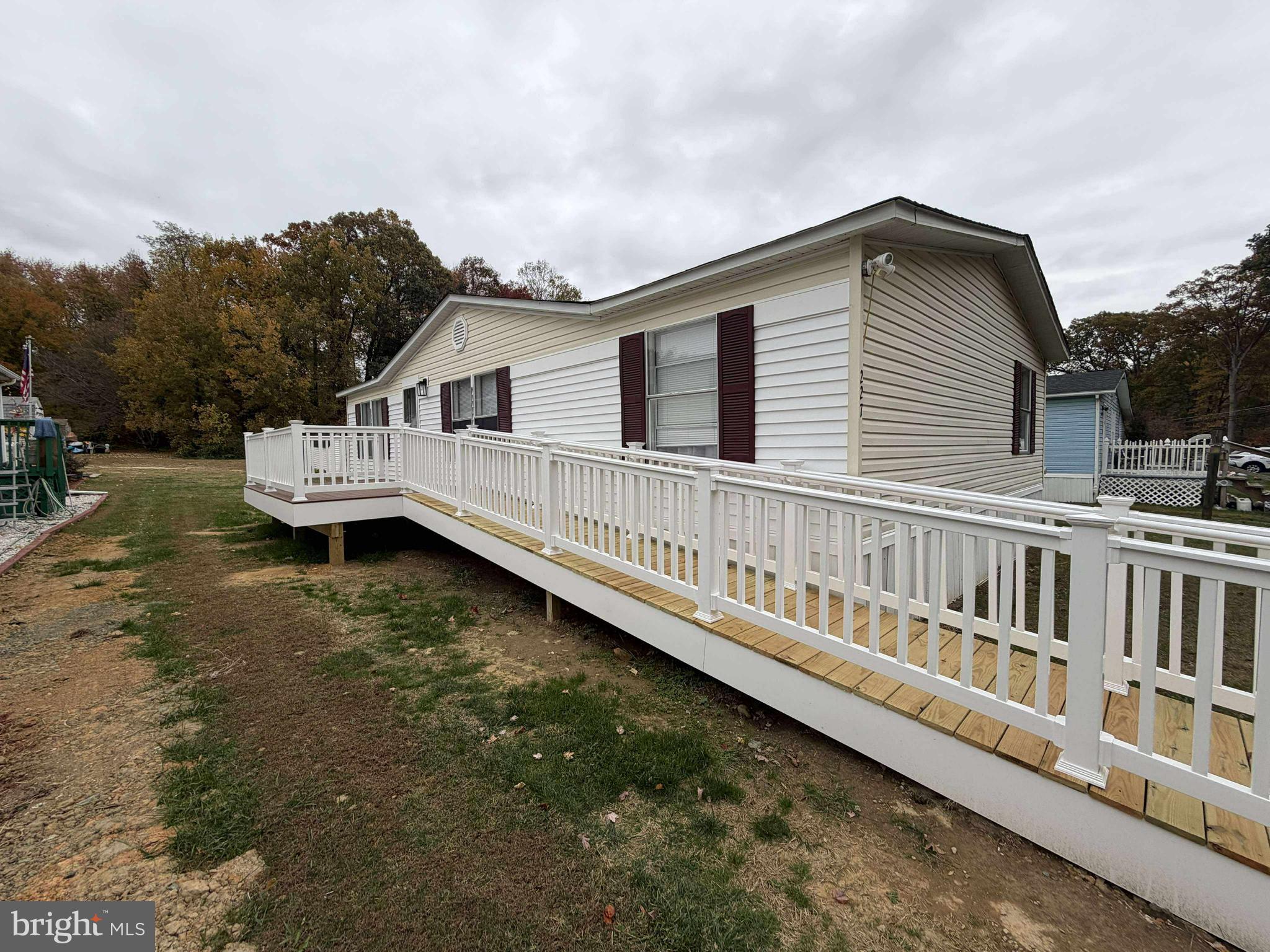 a view of a house with a wooden deck and a yard