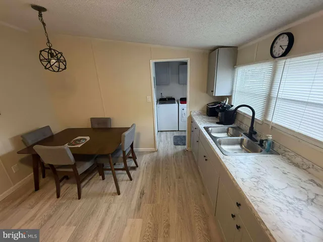 a kitchen with a sink cabinets and wooden floor